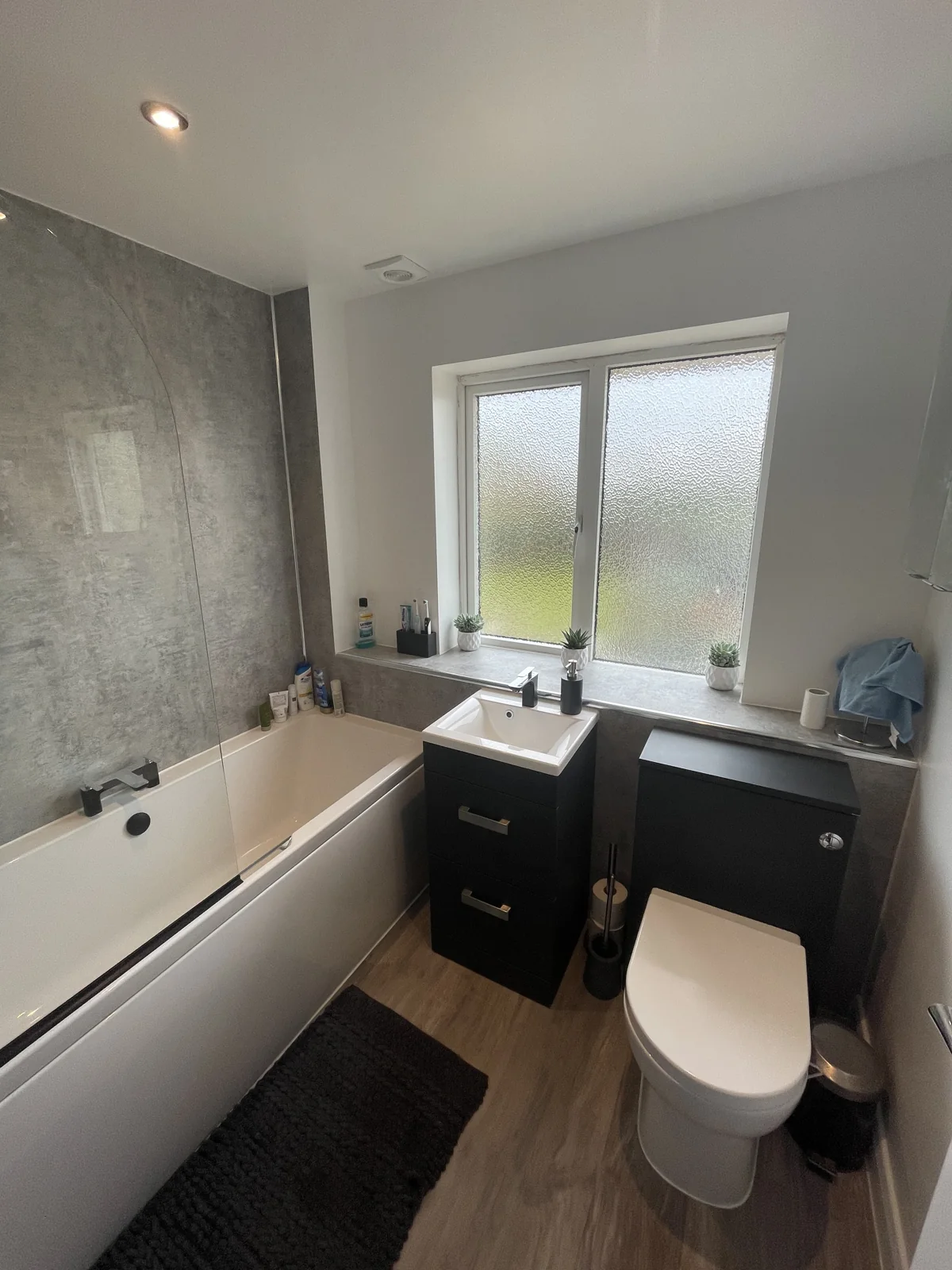 L&B bathroom refurbishment with a bath, black vanity and modern fittings