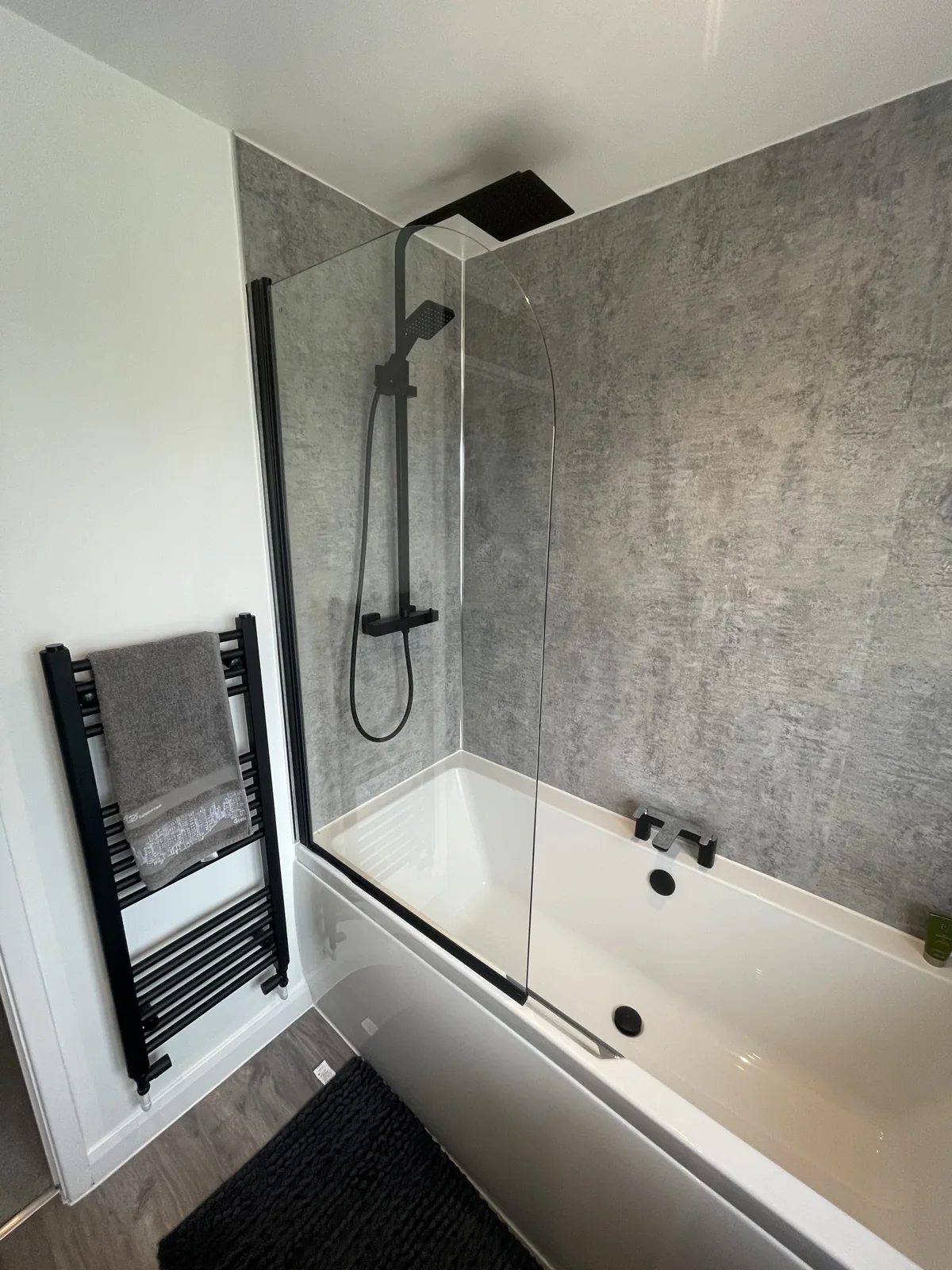 Black shower fittings, bath screen and matching towel radiator