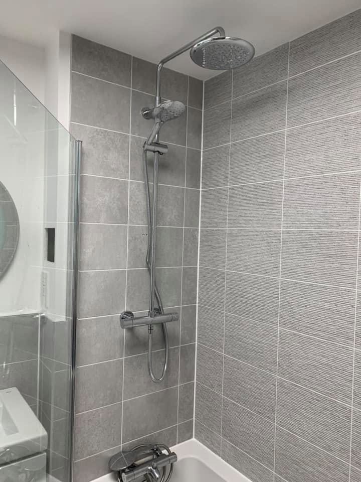 Chrome shower with rainfall head against grey tiles